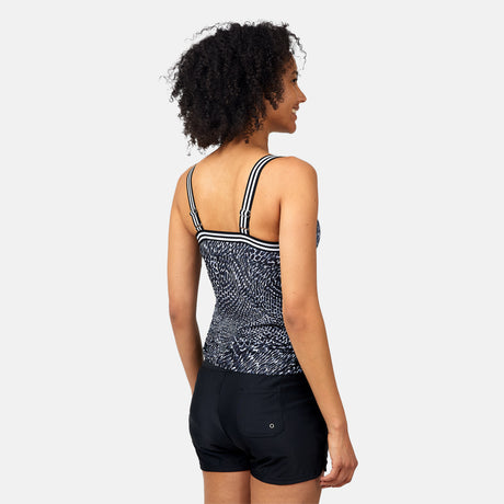 A woman with curly hair faces away, wearing the Clearance Women's Sea Skin Track Stripe Tankini with adjustable elastic straps and solid black swim shorts, set against a plain light background.
