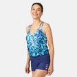 [Olga is 5'10" wearing size S.] Woman wearing a blue and purple patterned tankini top and navy swim shorts on a white background