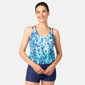 [Olga is 5'10" wearing size S.] Woman wearing a blue and purple patterned tankini top and navy swim shorts on a white background