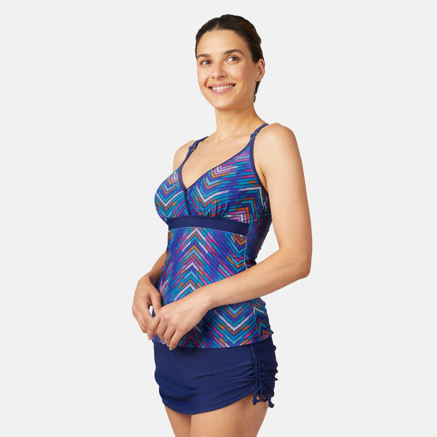 [Olga is 5'10" wearing size S.] Woman wearing a colorful blue tankini top and navy blue skirt on a white background