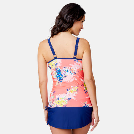 A woman with wavy brown hair is shown from the back, wearing a Clearance Women's Poolisde Bouquet Double Strap Tankini Top with adjustable straps and a navy quick dry swim skirt against a plain light background.