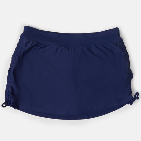 The Free Country Women's Side Shirred Swim Skirt, featuring adjustable side ties, a wide waistband, and a built-in brief, is shown in navy blue on a plain white background.