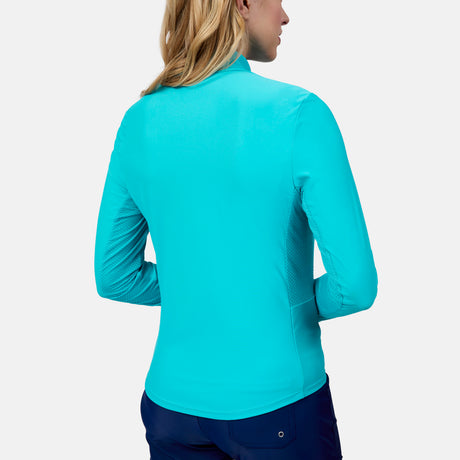 A woman with blonde hair, seen from behind, models the Free Country Women's Sun Breeze 1/2 Zip Sunshirt in bright blue with dark blue pants against a plain light background.