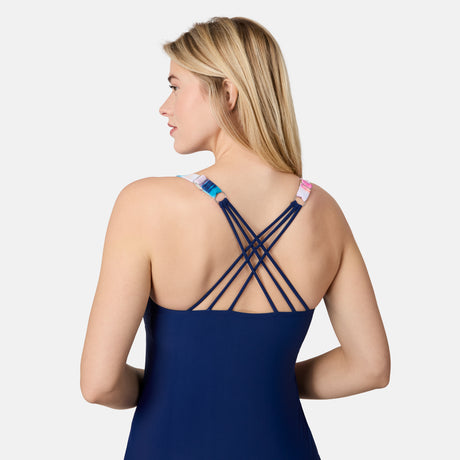[London is 5'9.5" wearing size S] Woman wearing a blue swimsuit with criss-cross back design on a white background