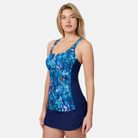 [London is 5'9.5" wearing size S] Woman wearing a blue patterned tankini top and navy skirt on a white background