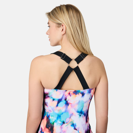 [London is 5'9.5" wearing size S] Woman wearing a colorful swimsuit with black criss-cross straps on a white background