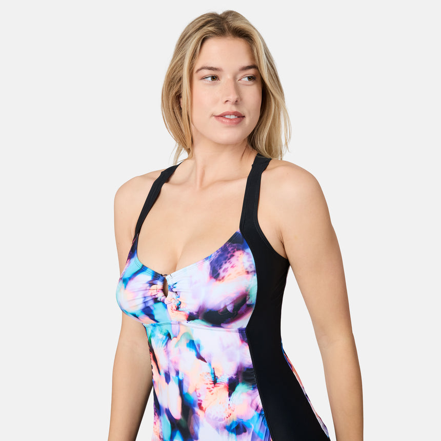 [London is 5'9.5" wearing size S] Woman wearing a colorful swimsuit with a black top on a white background