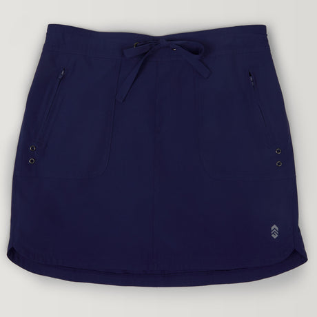 The Free Country Women's Plus Size Beach and Beyond Skort features a navy blue color, drawstring waistband, two zippered front pockets, metal grommets, a logo near the hem, and lightweight four-way stretch fabric with UPF 50+ sun protection.