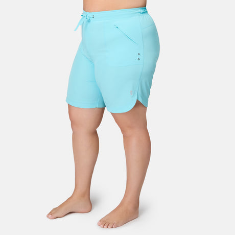 Light blue, quick-drying Free Country Women’s Plus Size 10″ Bermuda Board Shorts with an elastic drawstring waistband and a zippered pocket on the right leg.