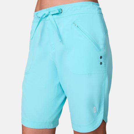 Light blue Free Country Women’s 7″ Bermuda Board Short with an elastic drawstring waist, zippered front pocket, and two eyelets on the hip.