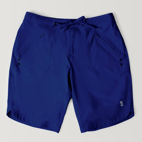 The Women's Bermuda Board Short II features a knee-length blue design, front zippered pockets, black button accents, a drawstring waistband, and quick-drying fabric, displayed on a light background.