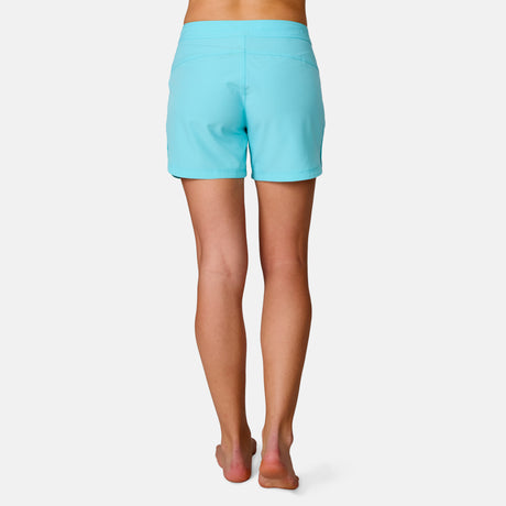 [Model is wearing a size Small.] Woman wearing Free Country Women's 5" Bermuda Board Short in Aqua, size S, made from quick drying UPF stretch performance fabric featuring a fly front zipper closure with a drawcord and two front pockets 