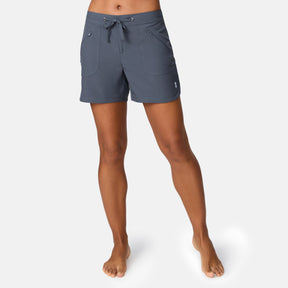 [Model is wearing a size Small.] Woman wearing Free Country Women's 5" Bermuda Board Short in Shadow, size S, made from quick drying UPF stretch performance fabric featuring a fly front zipper closure with a drawcord and two front pockets 