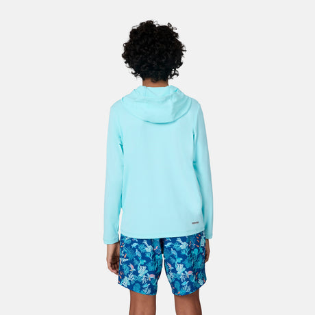 A child with short curly hair, seen from behind, wears the Free Country Kids' Everybody SunFree UPF Hoodie in light blue and tropical floral blue shorts, standing against a plain white background.