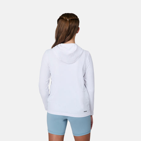 A child with long brown hair stands facing away, wearing the Free Country Kids' Everybody SunFree UPF Hoodie in white, made from recycled polyester, and light blue shorts against a plain light gray background.
