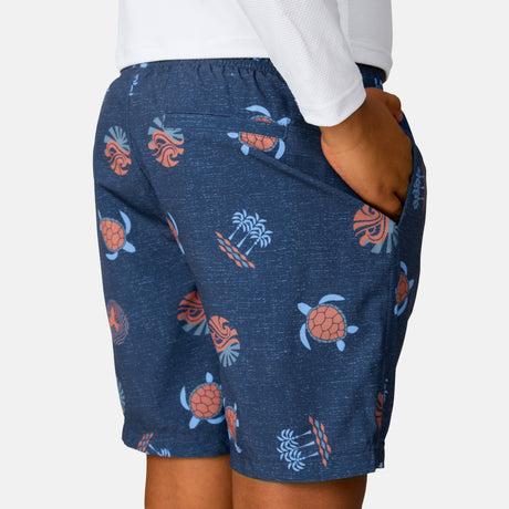 [Model is wearing a size Medium.] Boy wearing the Free Country Boys' Sunset Voyage Swim Short in Charcoal Sunset Voyage, size M, featuring recycled polyester fabric and elastic waistband and upf protection, paired with white sunshirt #color_ Charcoal-Sunset-Voyage