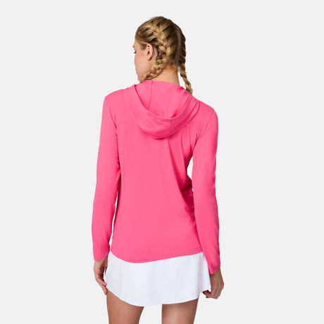 A woman with blonde braids models the Free Country Women's SunFree Full Zip UPF Sunshirt in bright pink, paired with a white skirt, standing with her back to the camera against a plain white background.