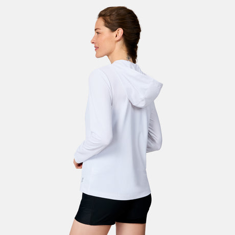 A woman wears the Free Country Women's SunFree Full Zip UPF Sunshirt in white and black shorts, standing sideways and looking left against a plain white background.