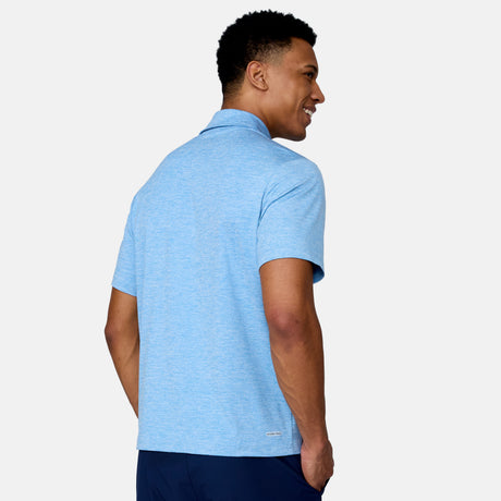 [Josiah is 6'3" wearing a size Medium.] Man wearing Free Country Men's SunFree UPF Polo Shirt in Blue, size M, made from anti-odor, breathable lightweight recycled polyester performance fabric featuring a classic active fit, styled with black shorts #color_blue