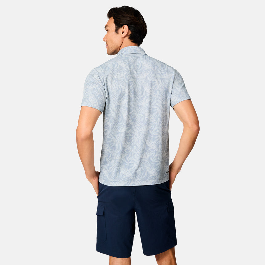 [Scott is 6’3" wearing size M] Man wearing a light blue patterned polo shirt and navy shorts on a white background