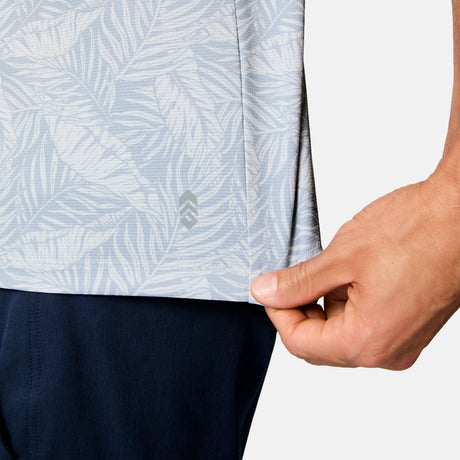 [Scott is 6’3" wearing size M] Close-up of a person wearing a light blue patterned shirt with navy pants on a plain background