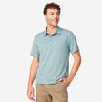[Miguel is 6'2" wearing a size Medium.] Man wearing Free Country Men's SunFree UPF Polo Shirt in Basil, size M, made from anti-odor, breathable lightweight recycled polyester performance fabric featuring a classic active fit, styled with black shorts #color_basil