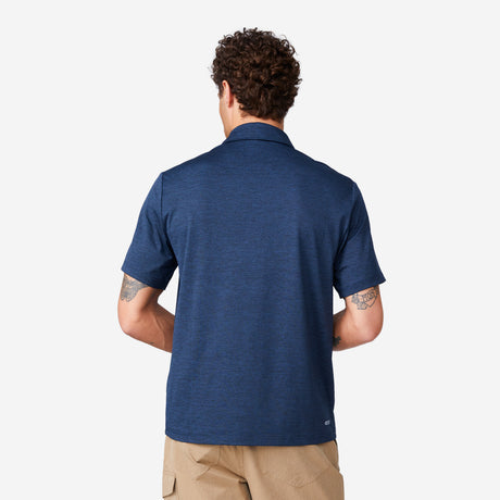 [Miguel is 6'2" wearing a size Medium.] Man wearing Free Country Men's SunFree UPF Polo Shirt in Navy, size M, made from anti-odor, breathable lightweight recycled polyester performance fabric featuring a classic active fit, styled with black shorts #color_navy