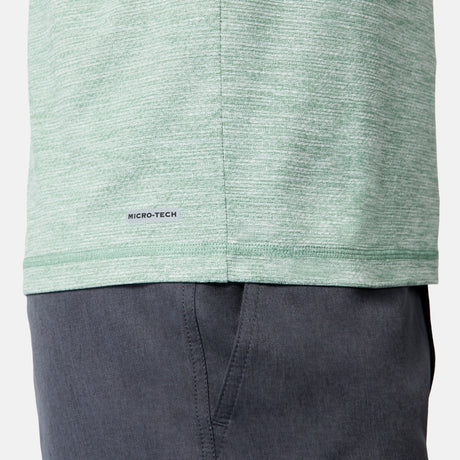Close-up of a person wearing the Free Country Men's Textured SunFree UPF Hoodie in light green and dark gray pants. The hoodie’s fabric provides moisture wicking and UPF 50+ sun protection for all-day comfort. Only part of the torso and upper leg is visible.