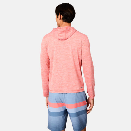 A man faces away wearing the Free Country Men's Textured SunFree UPF Hoodie in light red and blue swim shorts with pink and blue horizontal stripes, standing against a plain white background.