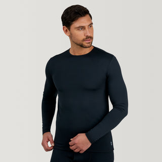 A man with short dark hair is wearing a fitted, long-sleeve black Men's Microtech® Heat Cocarber® Coffee Base Layer Top from Free Country, made from recycled materials. He stands against a plain light gray background, looking to his left.