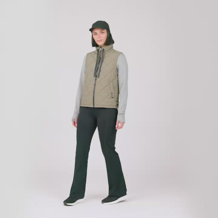 Model wearing the Women's Cirrus Diamond Quilted Vest in tan quilted with grey sleeves