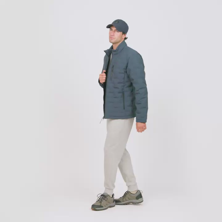 A male model wearing a gray Free Country puffer jacket, showing off its various features like zipper closure and pockets