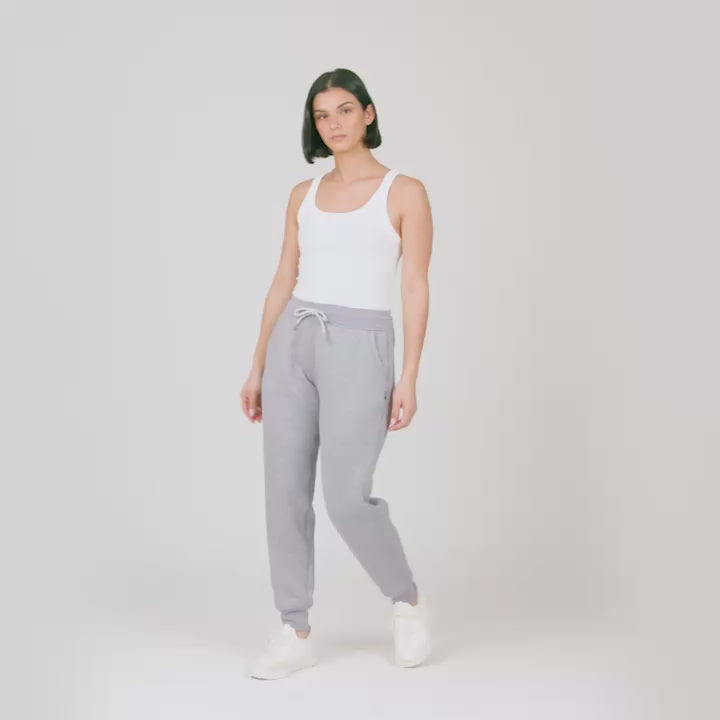 Model wearing the Women's Luxe+ Sherpa Lined Jogger in light grey, worn with a white tank top