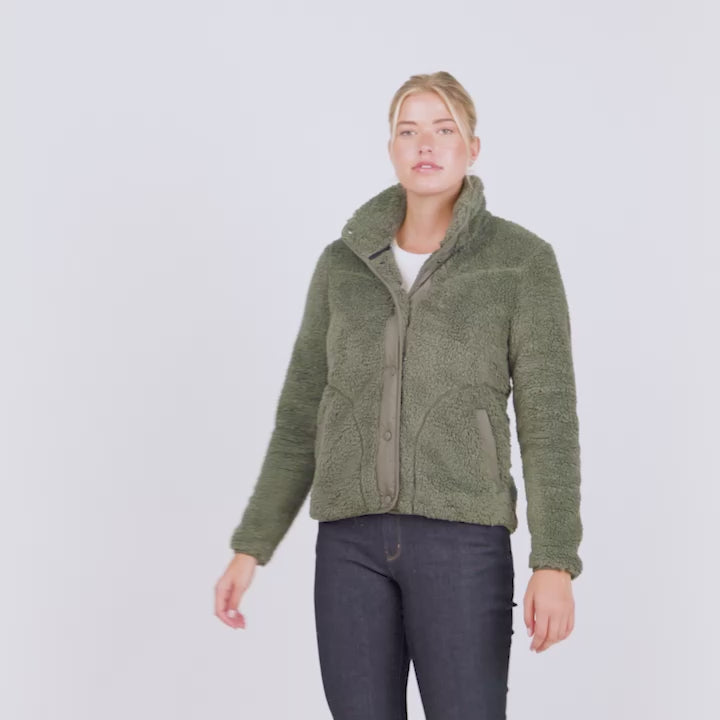 A model wearing a Free Country Sherpa jacket showing off its various features, like button front placket and lower pockets