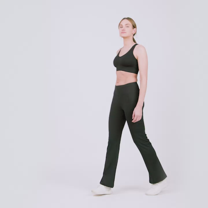 Model wearing the Women's Trail 2 Town Flare Pants in black, worn with a black sports bra