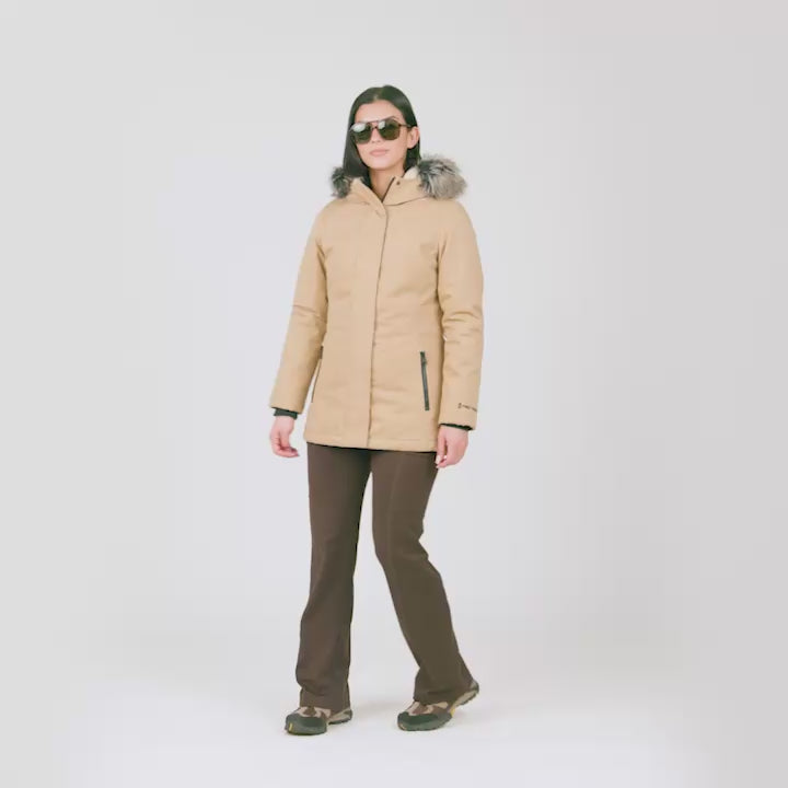 Model wearing the Women's Cascade Canvas Vanguard Parka Jacket in camel tan, worn with brown pants
