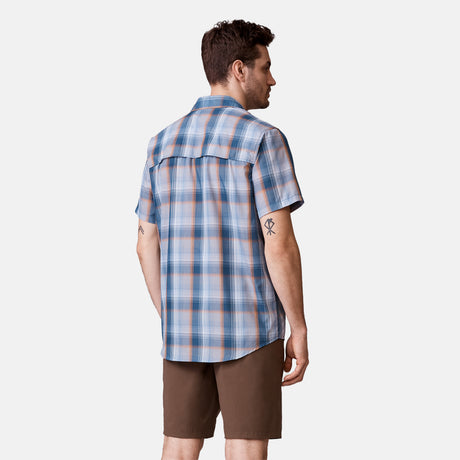 [Will is 6'2" wearing a size Medium.] Man is wearing Men's Excursion Short Sleeve Poplin Shirt in Dried Sage Plaid, size M, made from lightweight moisture wicking polyester fabric featuring vent at the back, full button down front, and a stand collar, styled with brown shorts #color_dried-sage