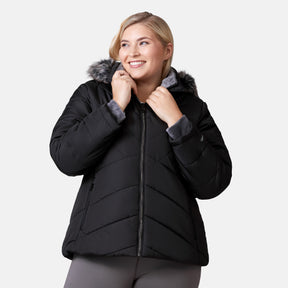 [Lola is 5'10.5" wearing a size 1X.] Woman wearing Free Country Women's Brisk II Parka Jacket in black with a full front zipper opening, soft lining, attached hood with faux fur trim, recycled polyester fill, and water resistant and wind resistant stretch performance fabric, light grey background. Perfect women’s  jacket for fall weather.