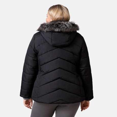 [Lola is 5'10.5" wearing a size 1X.] Woman wearing Free Country Women's Brisk II Parka Jacket in black with a full front zipper opening, soft lining, attached hood with faux fur trim, recycled polyester fill, and water resistant and wind resistant stretch performance fabric, light grey background. Perfect women’s  jacket for fall weather.